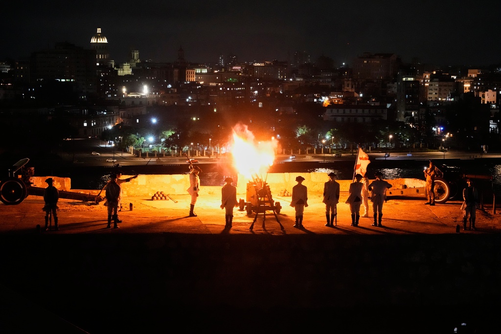 Soldiers dressed in historical uniforms fire a cannon during a nightly ceremony at San Carlos de la Cabaña Fortress in Havana, Monday, Jan. 26, 2026. (AP Photo/Ramon Espinosa)