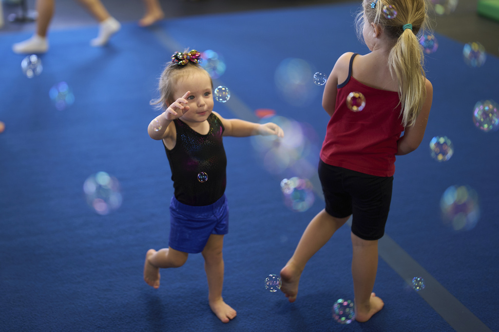 Brooklyn Marris, left, chases bubbles at the end of a gymnastics class in Winchester, Calif., on Thursday, Sept. 18, 2025. (AP Photo/Gregory Bull)