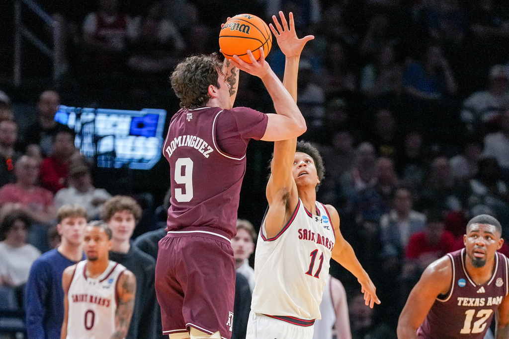Saint Mary's guard Dillan Shaw (11) tries to block a shot by Texas A&M guard Rubén Dominguez (9) during the first half in the first round of the NCAA college basketball tournament, Thursday, March 19, 2026, in Oklahoma City. (AP Photo/Kyle Phillips)