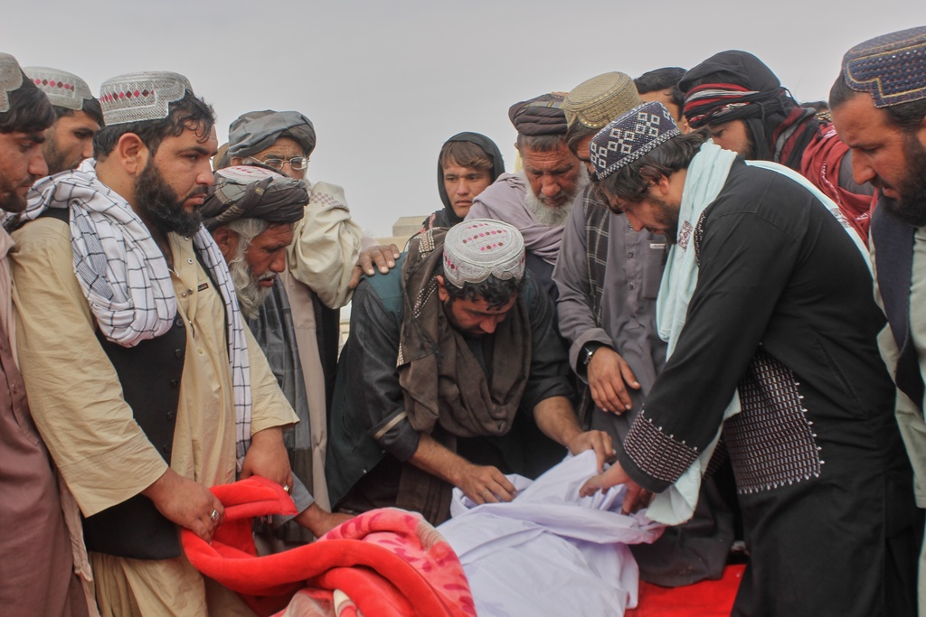 Afghans prepare the body of a man killed during an overnight exchange of fire between Afghan and Pakistani forces along the border in Spin Boldak, Kandahar province, Afghanistan, Saturday, Dec. 6, 2025. (AP Photo/Sibghatullah)