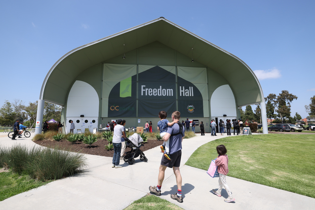 People arrive at Freedom Hall, an evacuation center in Fountain Valley, Calif., after a storage tank containing a chemical used to make plastic parts overheated Thursday at an aerospace plastics facility in Garden Grove, on Saturday, May 23, 2026. (AP Photo/Jill Connelly)