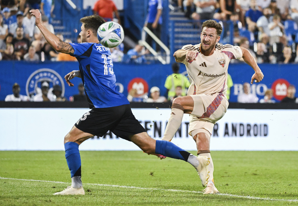 D.C. United's Conner Antley, right, shoots on goal as CF Montreal's Luca Petrasso, left, defends during first-half MLS soccer match action in Montreal, Saturday, Aug. 16, 2025. (Graham Hughes/The Canadian Press via AP)