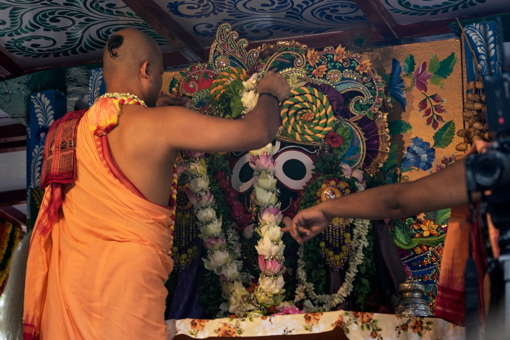 A Hindu priest garland the deity of Jagannath during the Rath Yatra, or chariot festival, carrying the Hindu deities of Jagannath, Balaram and Subhadra, in Kolkata, India, Thursday, July 16, 2026. (AP Photo/Bikas Das)