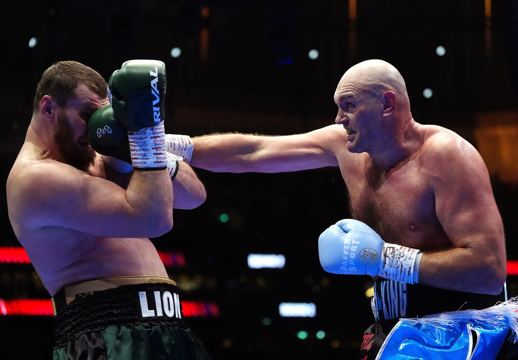 Boxer Tyson Fury, right, punches Arslanbek Makhmudov during a heavyweight bout at Tottenham Hotspur Stadium in London, Saturday, April 11, 2026. (Bradley Collyer/PA via AP)