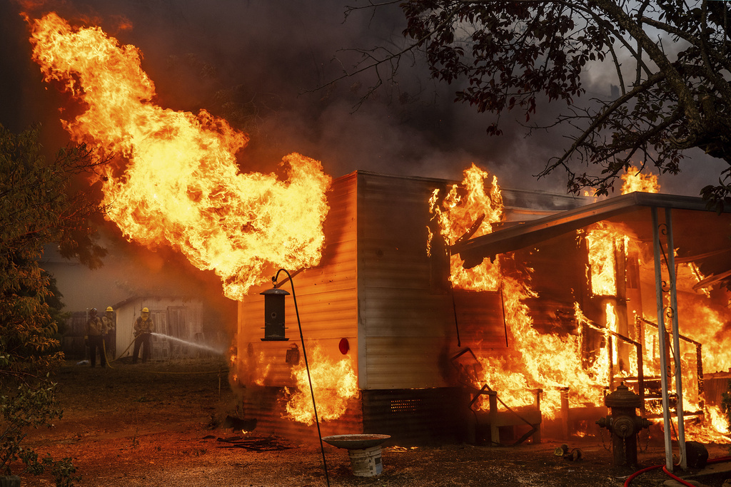 Flames consume a building as the 6-5 Fire burns through the Chinese Camp community of Tuolumne County, Calif., on Tuesday, Sept. 2, 2025. (AP Photo/Noah Berger)