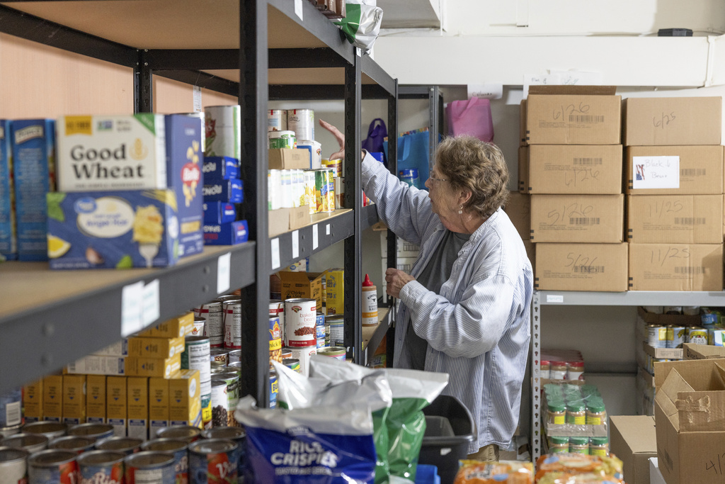 Phylis Allen organizes supplies at Neighbor's Cupboard in Winterport, Maine, on Tuesday, Aug. 26, 2025, a food pantry that she has helped run for the past 17 years. (Katherine Emery/The Maine Monitor via AP)