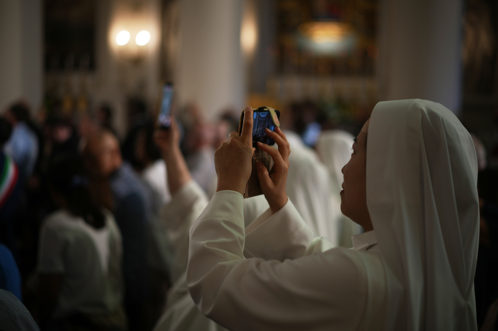 Faithful wait for Pope Leo XIV inside the Basilica during his visit to San Marino, Saturday, Aug. 22, 2026. (AP Photo/Andrew Medichini)