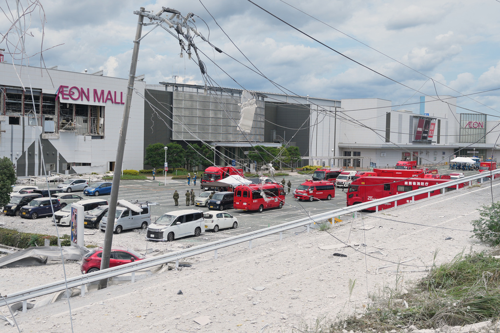 Emergency vehicles are seen in front of AEON Mall, which was damaged by an explosion following an earthquake, in Kashima, Kumamoto Prefecture, southern Japan, Wednesday, July 29, 2026. (AP Photo/Hiro Komae)