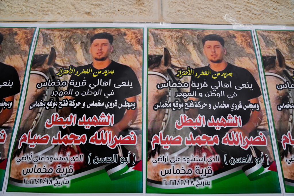 Posters with the name and picture of Palestinian-American Nasrallah Muhammad Jamal Abu Siyam, 19, who according to the Palestinian Health Ministry was shot by settlers on Wednesday night, are seen during his funeral in the West Bank village of Mukhmas, east of Ramallah, Thursday, Feb. 19, 2026. (AP Photo/Nasser Nasser)