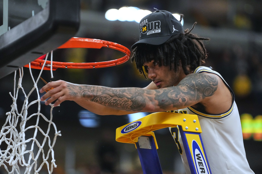 Michigan's Elliot Cadeau celebrates by cutting down the net after defeating Tennessee in the Elite Eight of the NCAA college basketball tournament, Sunday, March 29, 2026, in Chicago. (AP Photo/Erin Hooley)