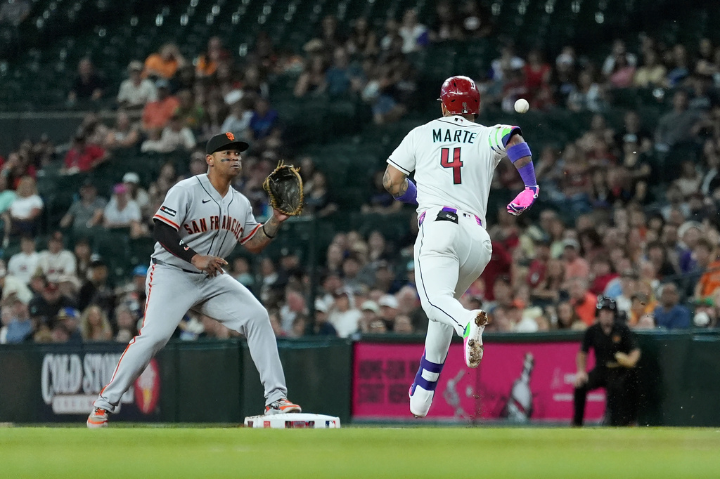 San Francisco Giants first baseman Rafael Devers, left, reaches out for the ball to get Arizona Diamondbacks' Ketel Marte (4) out at first base during the first inning of a baseball game, Tuesday, June 30, 2026, in Phoenix. (AP Photo/Ross D. Franklin)
