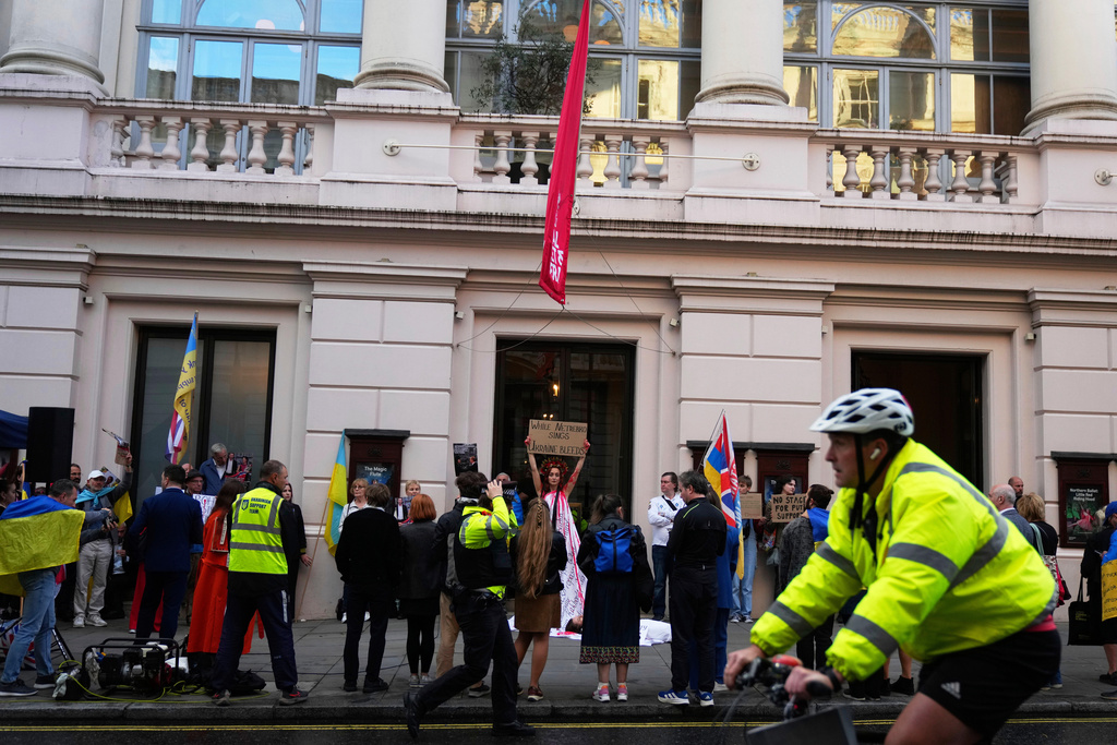 Pro-Ukraine protesters hold up placards and flags during a demonstration against the Royal Opera House in London, as the house had set an Russian opera singer to perform the lead in Puccini's Tosca, Thursday, Sept. 11, 2025. (AP Photo/Joanna Chan)