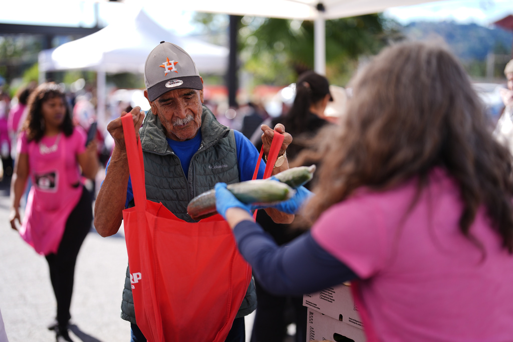 Angel Avila receives food aid at a distribution site for people affected by the wildfires on the one-year anniversary of the Eaton Fire Wednesday, Jan. 7, 2026, in Altadena, Calif. (AP Photo/Gregory Bull)