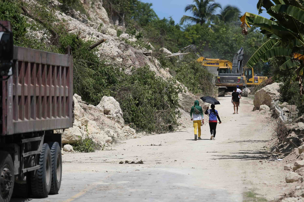 People walk past a landslide following an earthquake in Sarangani province, Philippines, Wednesday, June 10, 2026. (AP Photo/Basilio Sepe)
