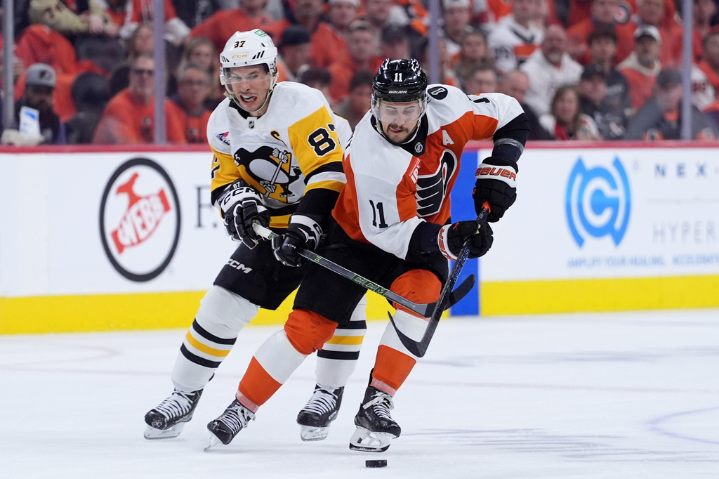Philadelphia Flyers' Travis Konecny, right, tries to keep the puck away from Pittsburgh Penguins' Sidney Crosby during the second period of Game 3 in the first round of the NHL Stanley Cup hockey playoffs Wednesday, April 22, 2026, in Philadelphia. (AP Photo/Matt Slocum)
