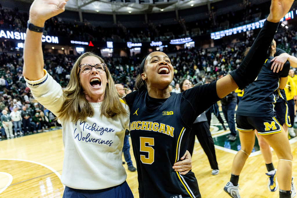 Michigan head coach Kim Barnes Arico, left, celebrates with guard Brooke Q. Daniels (5) after an NCAA college basketball game against Michigan State, Sunday, Feb. 1, 2026, in East Lansing, Mich. (Jake May/The Flint Journal via AP)