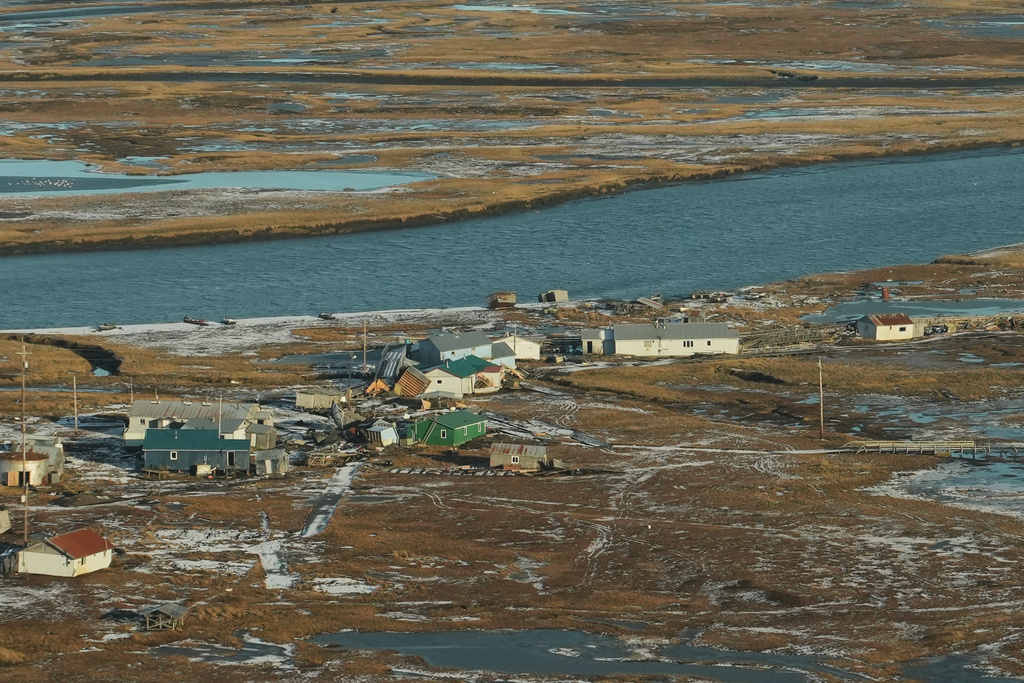Debris sits among homes and structures held back from floating into the river by a boardwalk in Kwigillingok, Alaska, Monday, Oct. 27, 2025, after Typhoon Halong hit the region earlier in the month. (AP Photo/Lindsey Wasson)