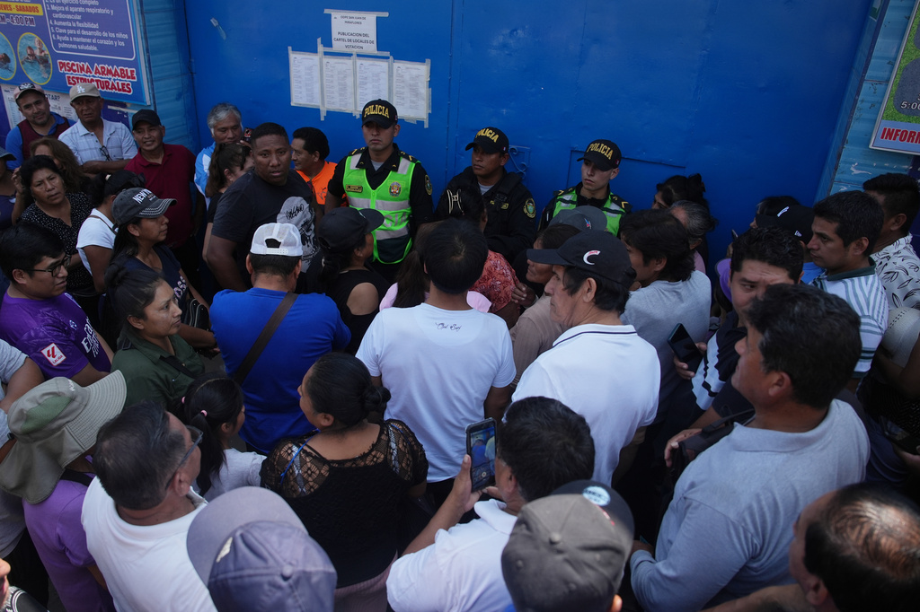 Voters line up outside a polling station that did not open during general elections in Lima, Peru, Sunday, April 12, 2026. (AP Photo/Guadalupe Pardo)