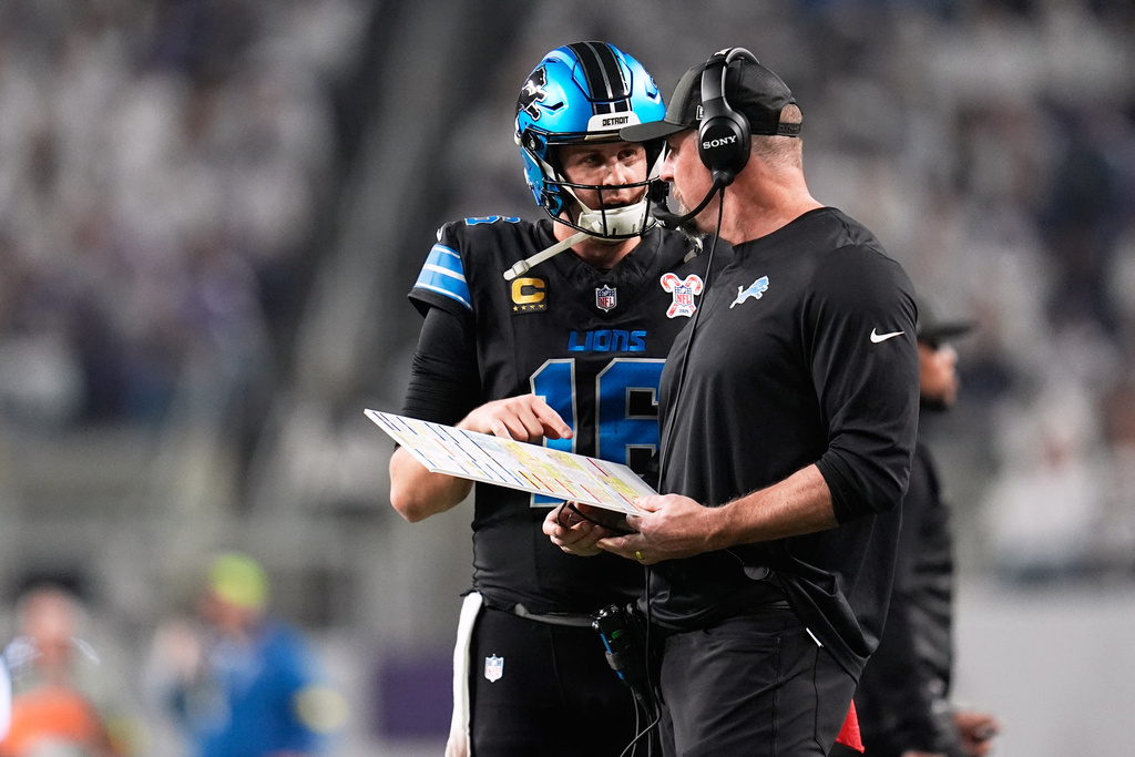 Detroit Lions quarterback Jared Goff, left, speaks with head coach Dan Campbell during the first half of an NFL football game against the Minnesota Vikings, Thursday, Dec. 25, 2025, in Minneapolis. (AP Photo/Abbie Parr)