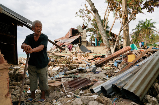 FILE -Bernardino Aspacio walks past rubbles from his damaged house due to Typhoon Rai in Alegria, Cebu province, central Philippines, Dec. 22, 2021. (AP Photo/Jay Labra, File) FILE -Bernardino Aspacio walks past rubbles from his damaged house due to Typhoon Rai in Alegria, Cebu province, central Philippines, Dec. 22, 2021. (AP Photo/Jay Labra, File)