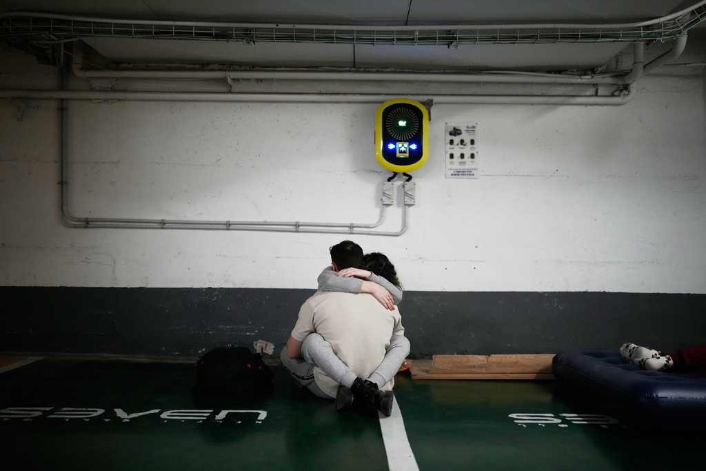 People take shelter in an underground parking garage as air raid sirens warn of incoming missiles strike by Iran, in Tel Aviv, Israel, Saturday, Feb. 28, 2026. (AP Photo/Ohad Zwigenberg)