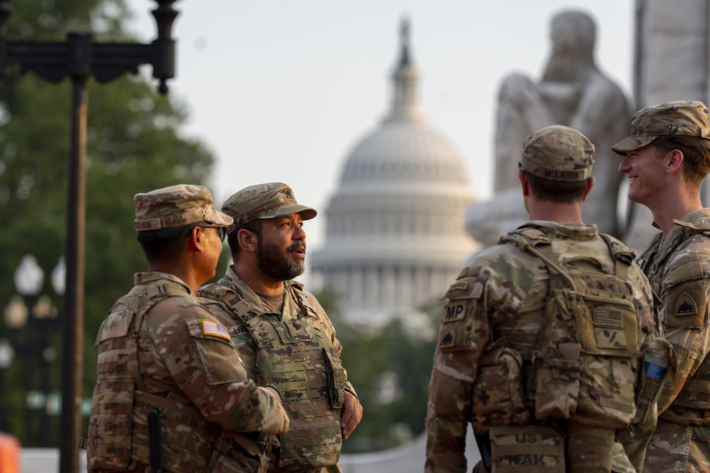 District of Columbia National Guard soldiers stand at Union Station with the U.S. Capitol behind them in Washington, Friday, Aug. 15, 2025, in Washington. (AP Photo/Alex Brandon)