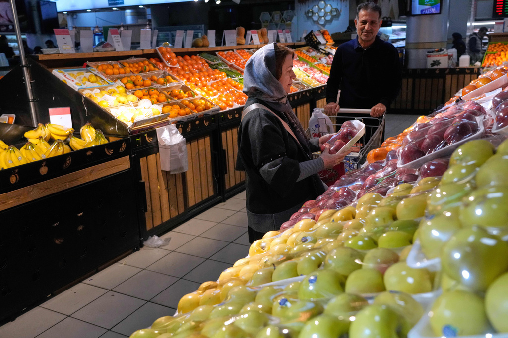 People shop fruits at a store in Tehran, Iran, Friday, Jan. 16, 2026. (AP Photo/Vahid Salemi)