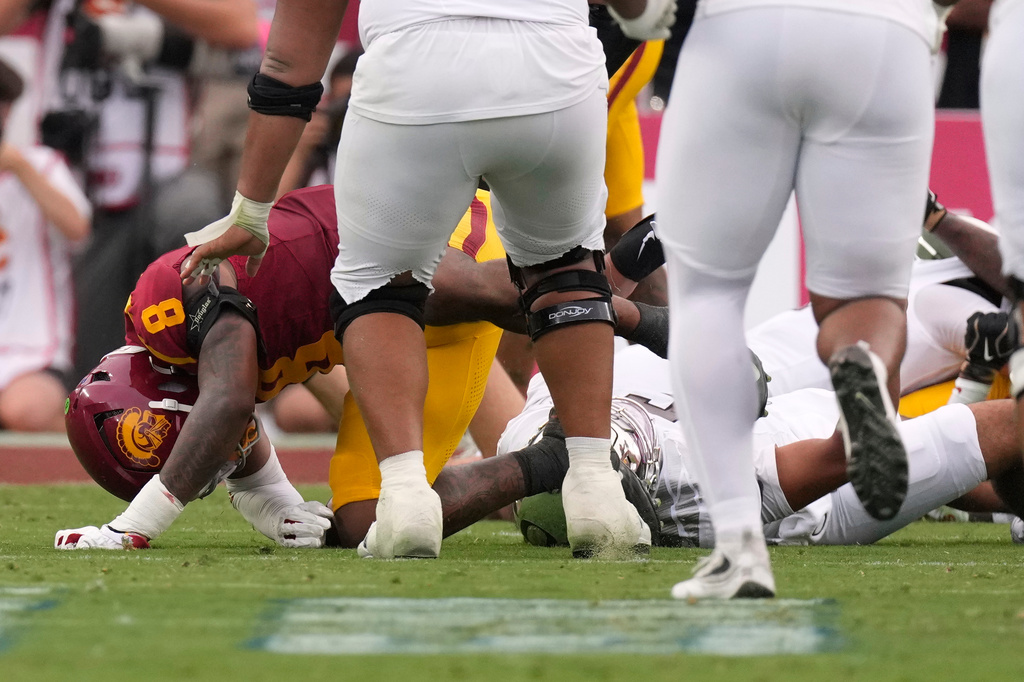 Oregon quarterback Dante Moore, bottom right, takes a hard tackle by Southern California linebacker Desman Stephens II (8) during the first half of an NCAA college football game, Saturday, Sept. 26, 2026, in Los Angeles. (AP Photo/Mark J. Terrill)