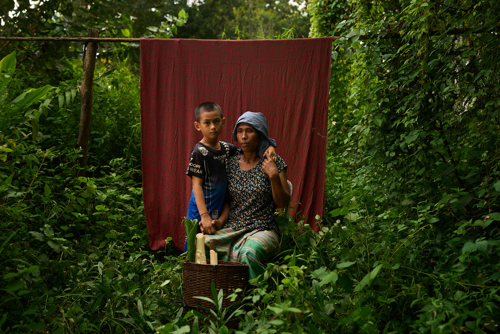 Naung Pate, right, poses for a portrait with her son after foraging for food in the forest near the refugee camp, in the Tak province of Thailand, Saturday, Aug. 30, 2025. (AP Photo/Bram Janssen)
