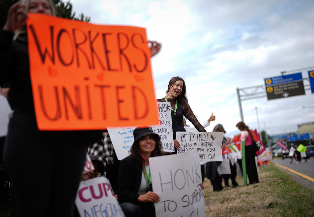 Striking Air Canada flight attendants rally at Vancouver International Airport, in Richmond, British Columbia, Monday, Aug. 18, 2025. (Darryl Dyck/The Canadian Press via AP)