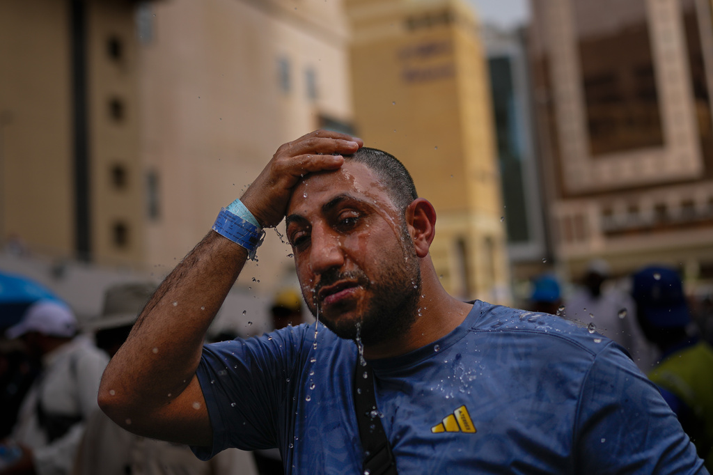 A Muslim pilgrim splashes water over his head too cool down outside the Grand Mosque during the annual hajj pilgrimage at the holy city of Mecca, Saudi Arabia, Sunday, May 24, 2026. (AP Photo/Altaf Qadri)