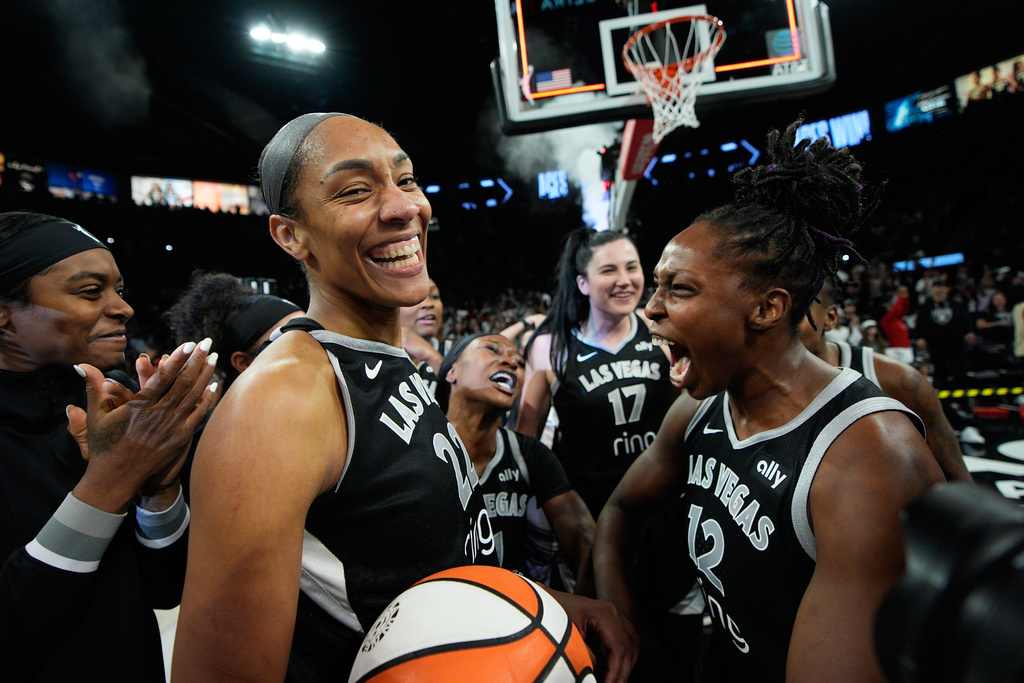 Las Vegas Aces center A'ja Wilson (22) and Las Vegas Aces guard Chelsea Gray (12) celebrate after the Las Vegas Aces defeated the Indiana Fever in Game 5 of a WNBA basketball playoff semifinals series Tuesday, Sept. 30, 2025, in Las Vegas. (AP Photo/John Locher)
