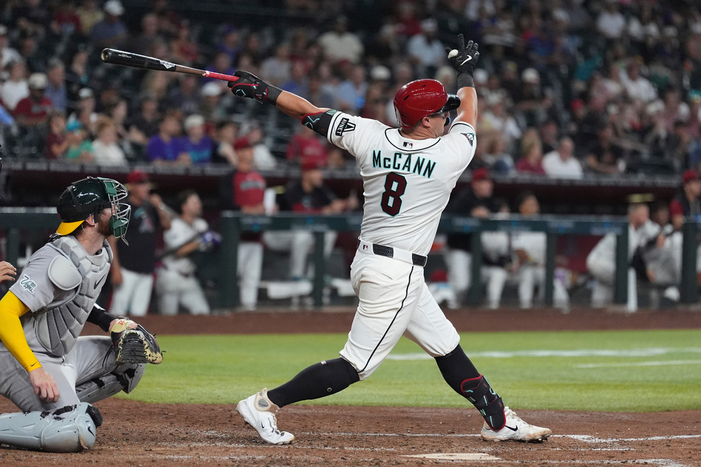 Arizona Diamondbacks' James McCann (8) watches the flight of his two-run home run as Athletics catcher Jonah Heim looks on during the fifth inning of a baseball game, Wednesday, July 22, 2026, in Phoenix. (AP Photo/Ross D. Franklin)