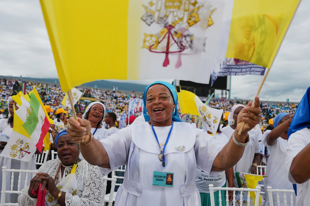 Faithful sing as they wait for Pope Leo XIV to celebrate Mass at Malabo Stadium in Malabo, Equatorial Guinea, Thursday, April 23, 2026. (AP Photo/Misper Apawu)
