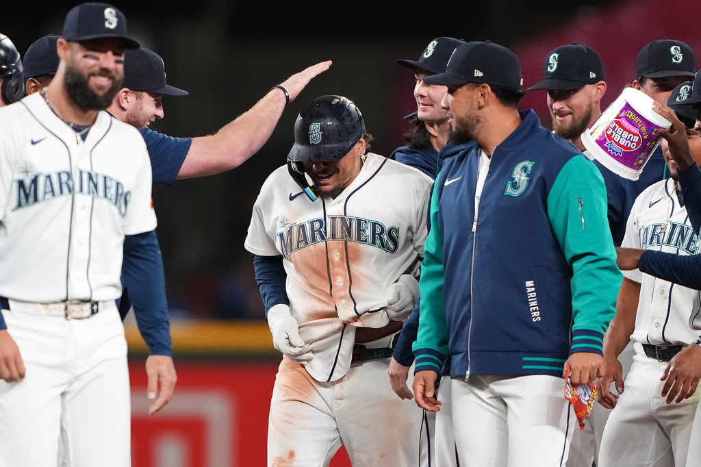 Seattle Mariners' Josh Naylor, center, celebrates with teammates after hitting a walk-off RBI single against the Houston Astros in the 10th inning of a baseball game, Wednesday, Sept. 23, 2026, in Seattle. (AP Photo/Lindsey Wasson)