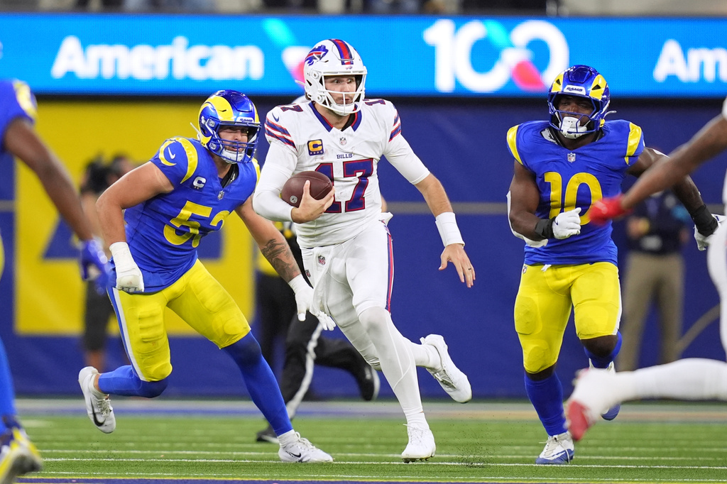 Buffalo Bills quarterback Josh Allen, center, runs the ball as Los Angeles Rams linebacker Nate Landman, left, and linebacker Josaiah Stewart chase during the second half of an NFL football game, Monday, Oct. 12, 2026, in Inglewood, Calif. (AP Photo/Gregory Bull)