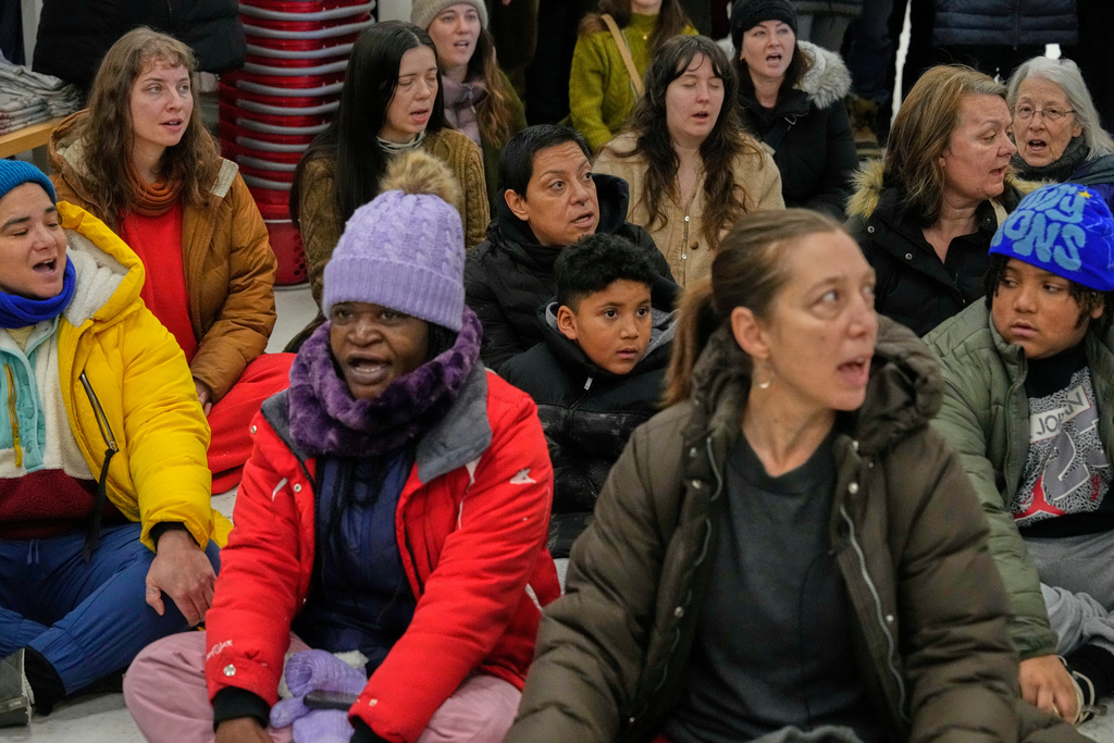 Community members and neighbors of people detained by ICE sing during a protest at a Target store, Monday, Jan. 19, 2026, in St. Paul, Minn. (AP Photo/Yuki Iwamura)
