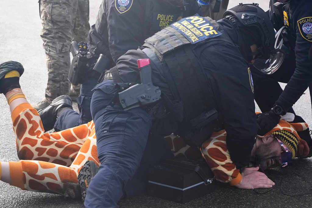 Rob Potylo, aka Robby Roadsteamer, wearing a giraffe costume he calls the "Jeffrey Epstein Giraffe", is arrested by police from the homeland security rapid protection force, during a protest outside of the Bishop Whipple Federal Building, Monday, Jan. 12, 2026, in Minneapolis. (AP Photo/Jen Golbeck)