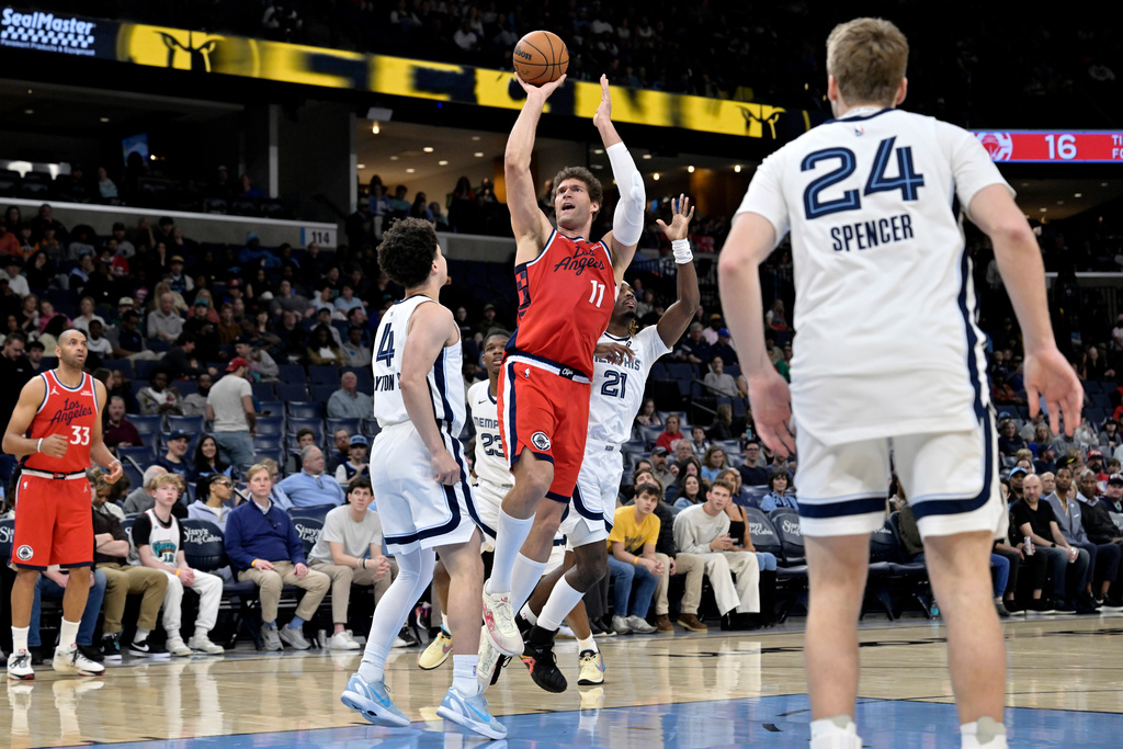 Los Angeles Clippers center Brook Lopez (11) shoots over Memphis Grizzlies guards Walter Clayton Jr. (4) and Jahmai Mashack (21) in the first half of an NBA basketball game Saturday, March 7, 2026, in Memphis, Tenn. (AP Photo/Brandon Dill)