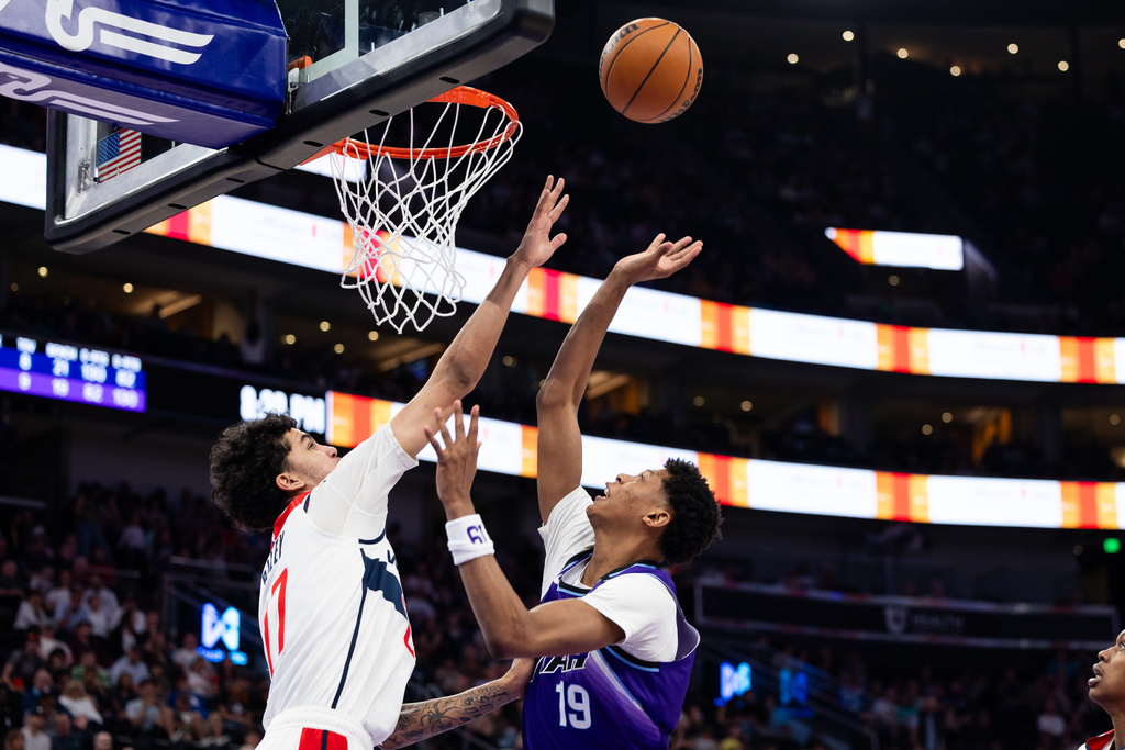Washington Wizards forward Will Riley, left, defends Utah Jazz forward Ace Bailey (19) as he shoots during the second half of an NBA basketball game, Wednesday, March 25, 2026, in Salt Lake City. (AP Photo/Anna Fuder)