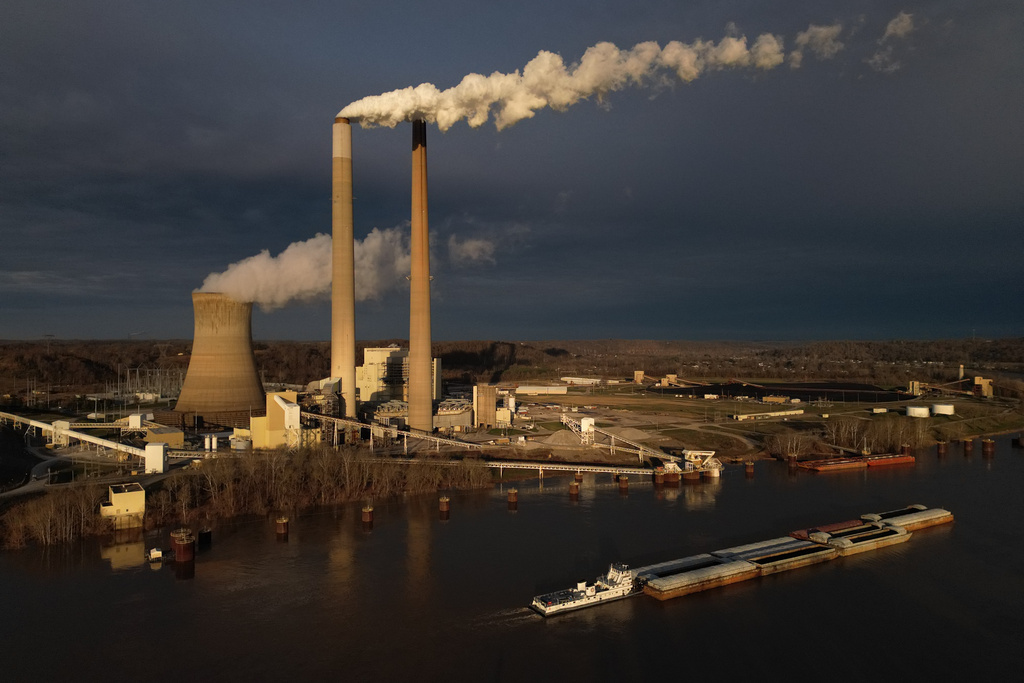 A barge on the Ohio River moves past the Mountaineer Power Plant, a coal-fired power plant near New Haven, W.Va., early Friday, March 13, 2026. (AP Photo/Carolyn Kaster)