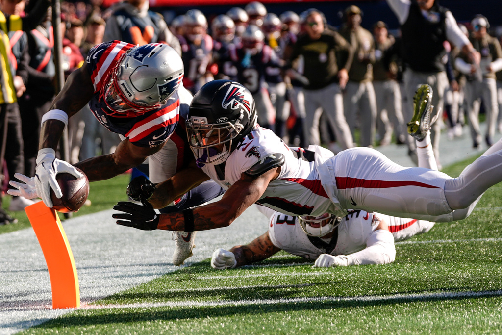 New England Patriots wide receiver Stefon Diggs (8) scores a touchdown against Atlanta Falcons cornerback Mike Hughes (21) during the first half of an NFL football game, Sunday, Nov. 2, 2025, in Foxborough, Mass. (AP Photo/Charles Krupa)