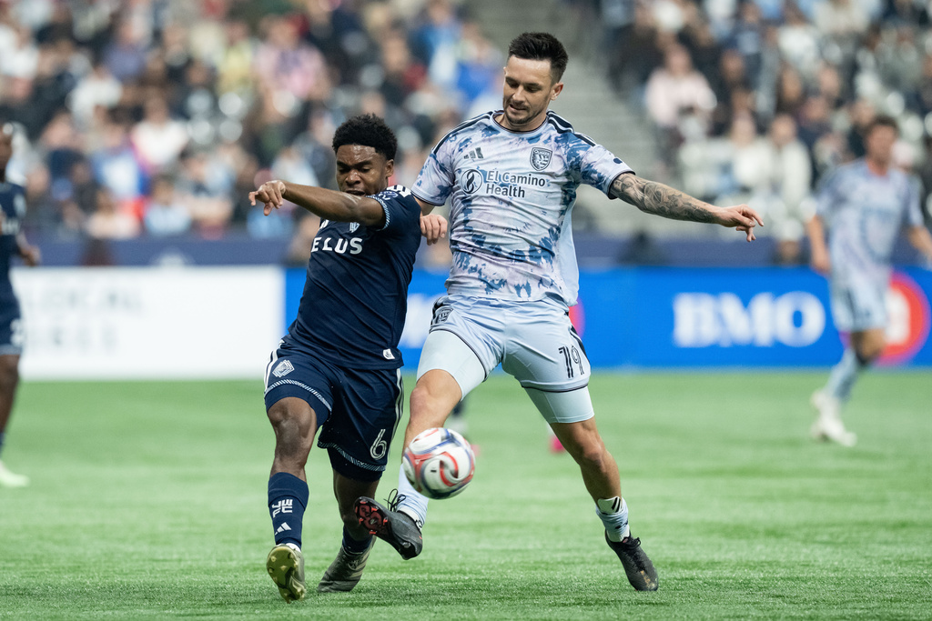 Vancouver Whitecaps' Ralph Priso (6) and San Jose Earthquakes' Preston Judd (19) vie for the ball during the first half of an MLS soccer match in Vancouver, British Columbia, Saturday, March 21, 2026. (Ethan Cairns/The Canadian Press via AP)