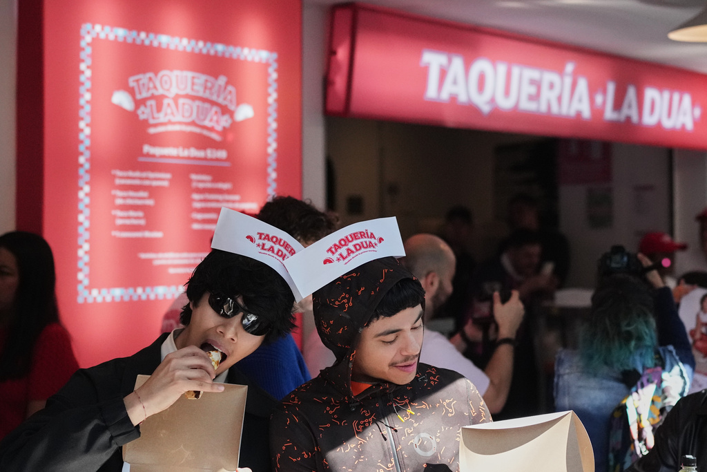 People eat tacos at the opening of Dua Lipa's taqueria, a pop-up restaurant for her fans, in Mexico City, Monday, Dec. 1, 2025. (AP Photo/Eduardo Verdugo)