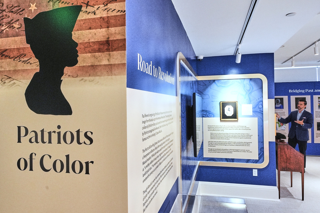 Ryan J. Woods, President & Chief Executive Officer of the American Ancestors museum, far right, gives a tour of the "Patriots of Color" exhibition at the museum, Wednesday, April 15, 2026, in Boston. (AP Photo/Charles Krupa)