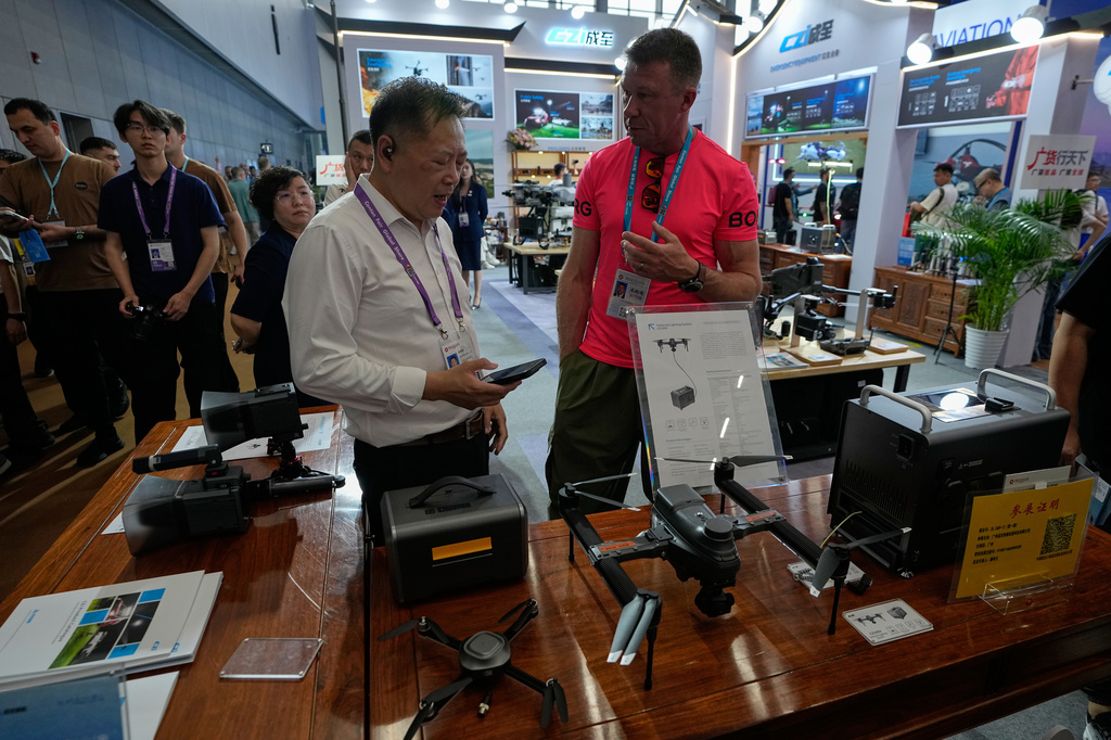A vendor attends a visitor at a booth showcasing drones at the Canton Fair, in Guangzhou, in southern China's Guangdong province, Wednesday, April 15, 2026. (AP Photo/Andy Wong)