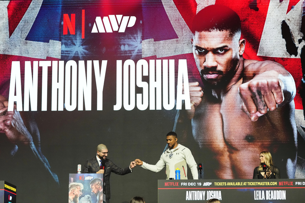 Anthony Joshua, right, is introduced during a news conference promoting his upcoming heavyweight boxing match against Jake Paul, Wednesday, Dec. 17, 2025, in Miami Beach, Fla. (AP Photo/Lynne Sladky)