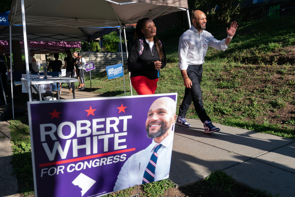 D.C. Council member Robert White Jr., accompanied by his wife Christy, waves to supporters after casting his vote during the D.C. primary election at Shepard Park Elementary, Tuesday, June 16, 2026, in Washington. (AP Photo/Jose Luis Magana)