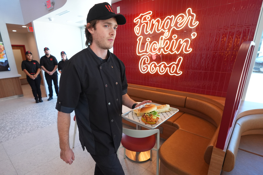 Jacob Mitchell carries a tray of food at new KFC restaurant pre-opening presentation in McKinney, Texas, Tuesday, Sept. 22, 2026. (AP Photo/LM Otero)
