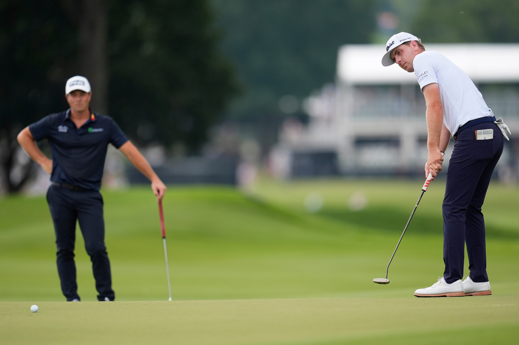 Ryan Gerard putts on the first green as Viktor Hovland, of Norway, looks on during the third round of the PGA Tour Championship golf tournament, Saturday, Aug 29, 2026, in Atlanta.(AP Photo/Mike Stewart)